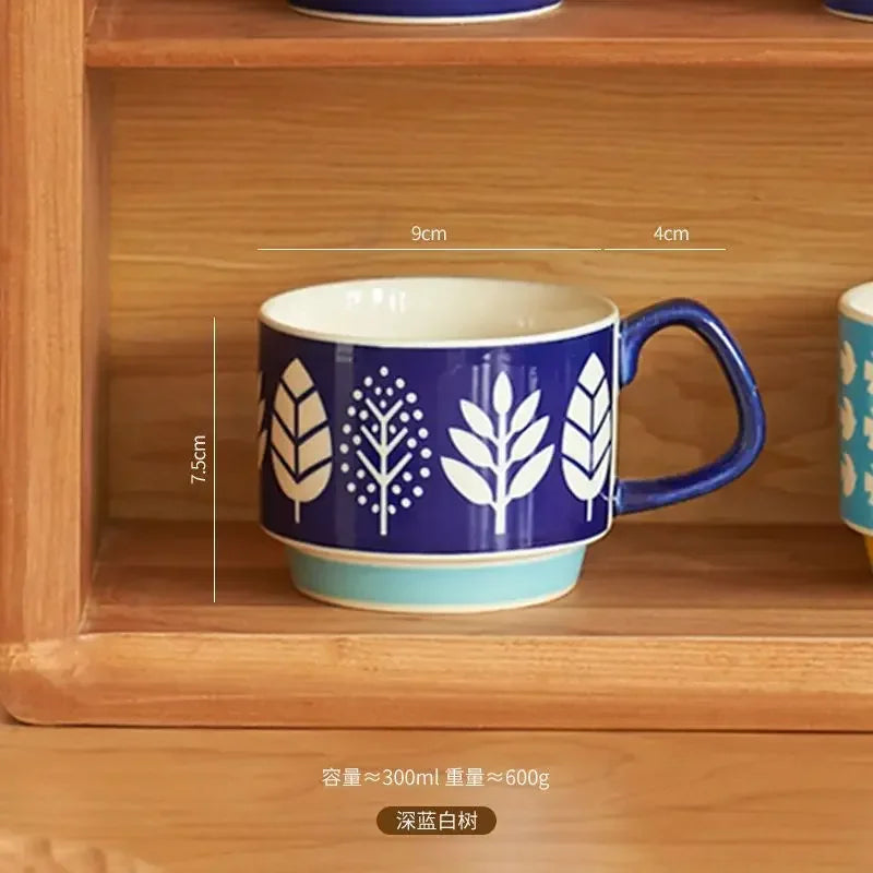 Blue mug with white leaf patterns on a wooden shelf