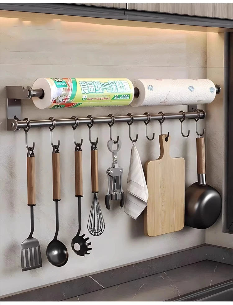Kitchen wall organizer with utensils, cutting boards, and paper towels.