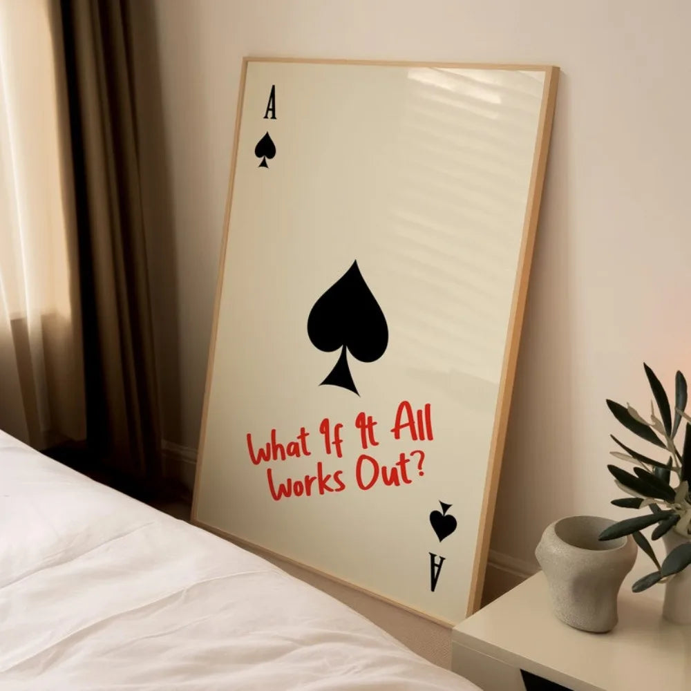 Framed playing card with spade symbol and text 'What If It All Works Out?' on a wall.