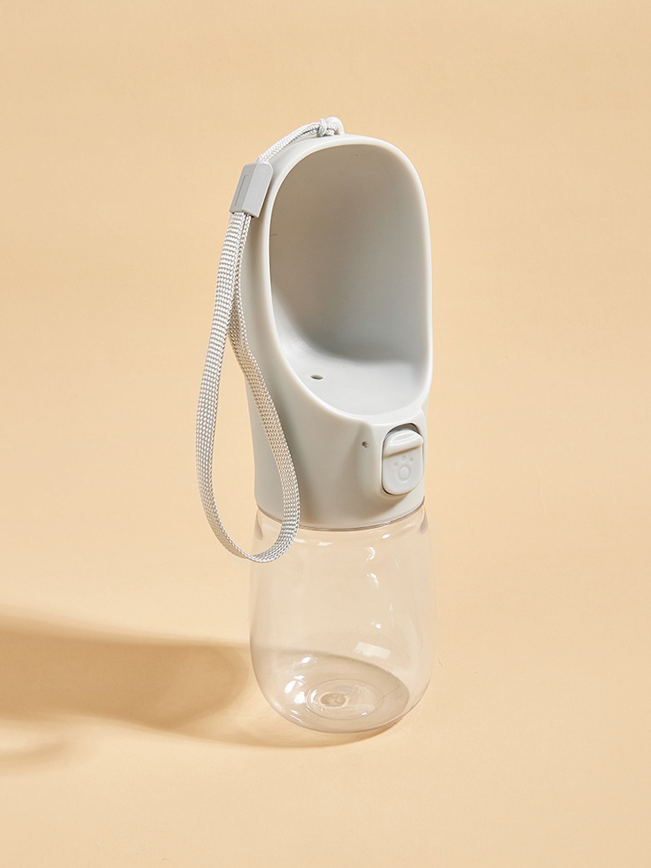 Portable water bottle with a carrying strap on a beige background
