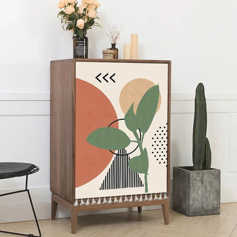 Wooden cabinet with abstract design in a room with a plant and candles