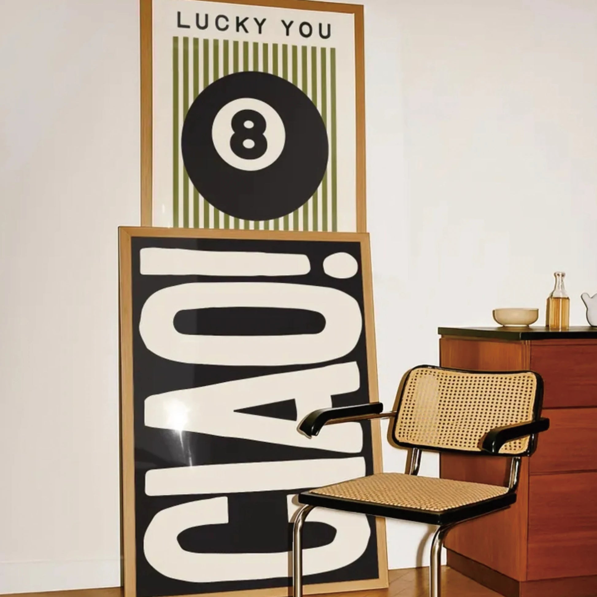 Set of three modern wall art prints featuring 8 ball, typography and graphic design displayed in a living room setting