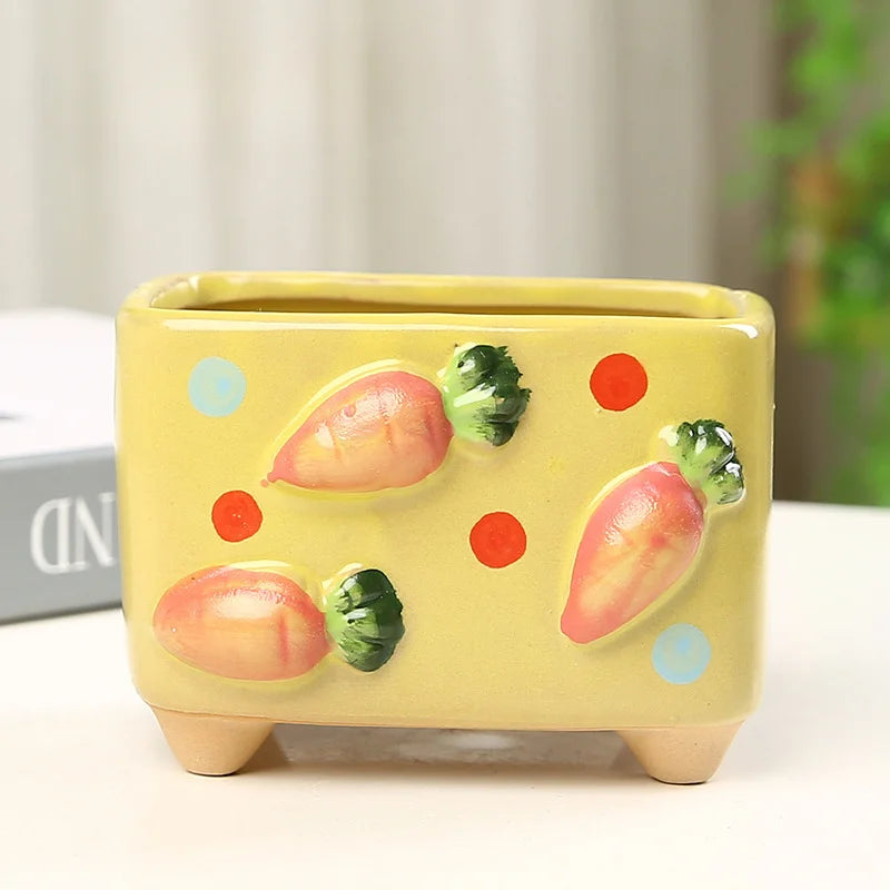 Yellow ceramic planter with carrot and mushroom designs on a white surface.