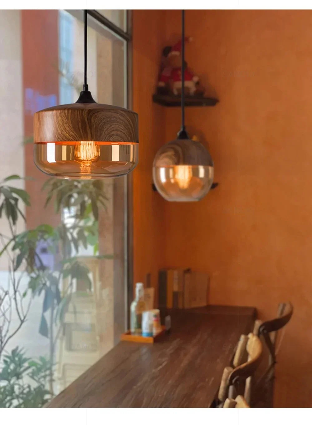 Wooden pendant lights hanging above a wooden table with an orange wall in the background.