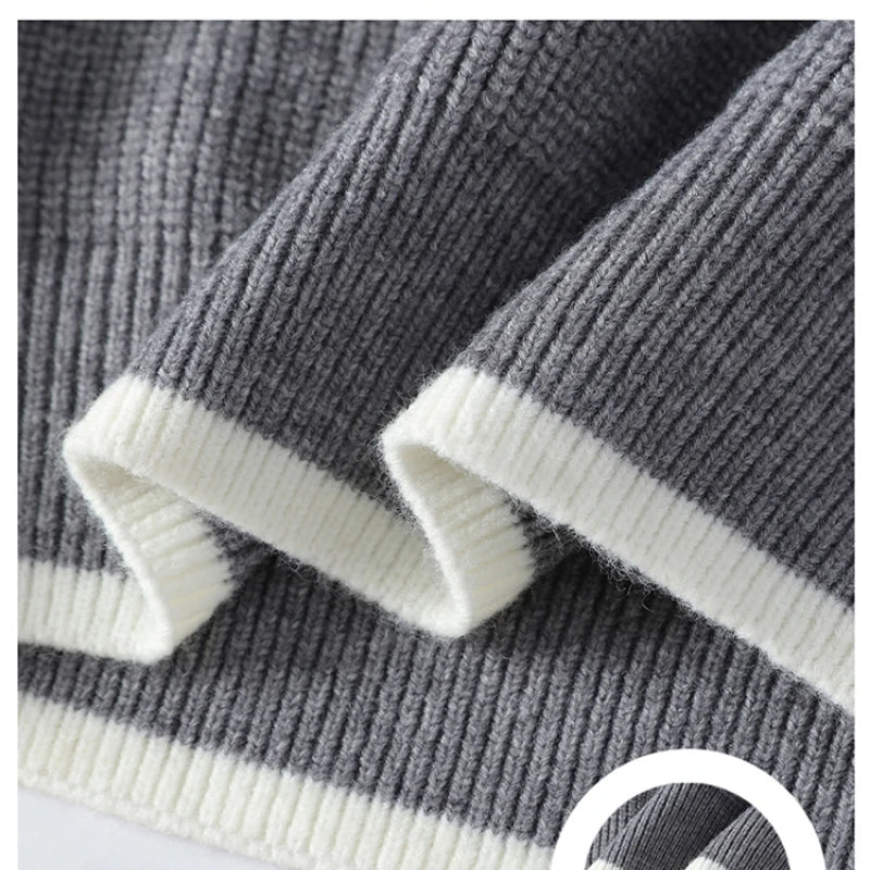 Close-up of a gray and white striped sweater with ribbed cuffs and hem.