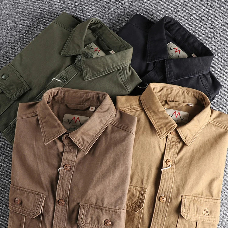 Four folded shirts in green, black, brown, and beige on a textured surface.
