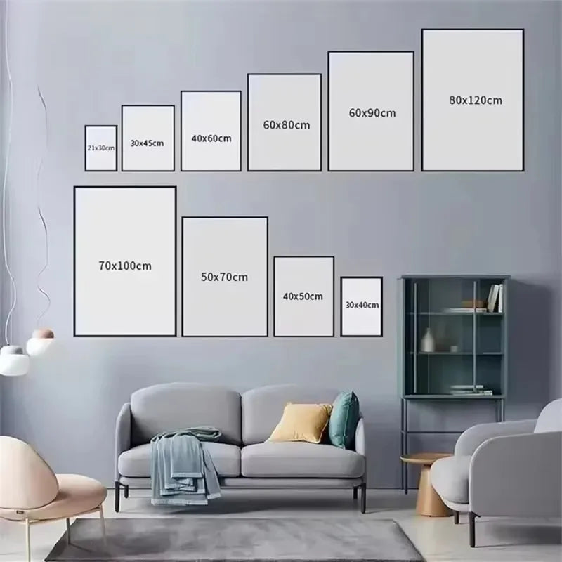 Wall with various size frames displayed against a gray wall with a sofa and chairs.
