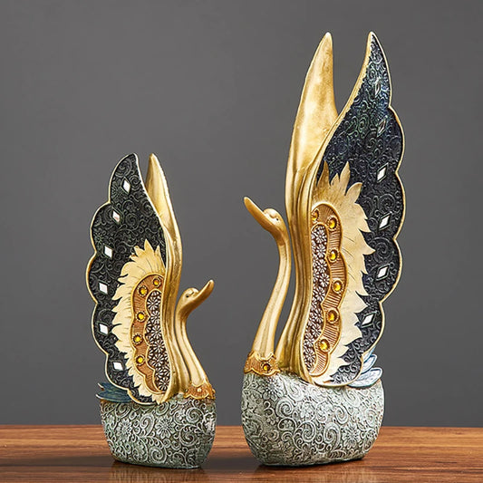 Decorative swan statues with intricate designs on a wooden surface and dark background