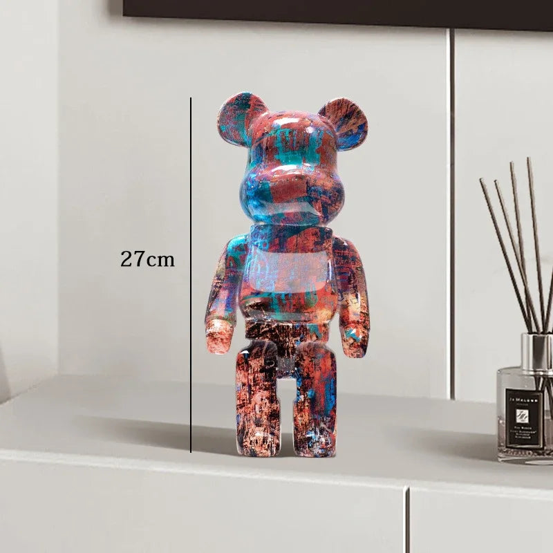 Colorful bear-shaped figure on a white surface with a measurement label, next to a diffuser.