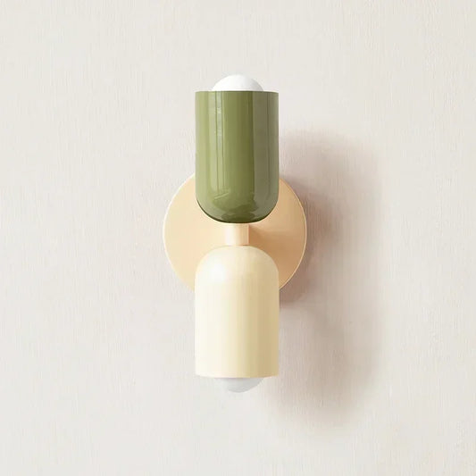 Wall-mounted light fixture with green and beige design on a plain background