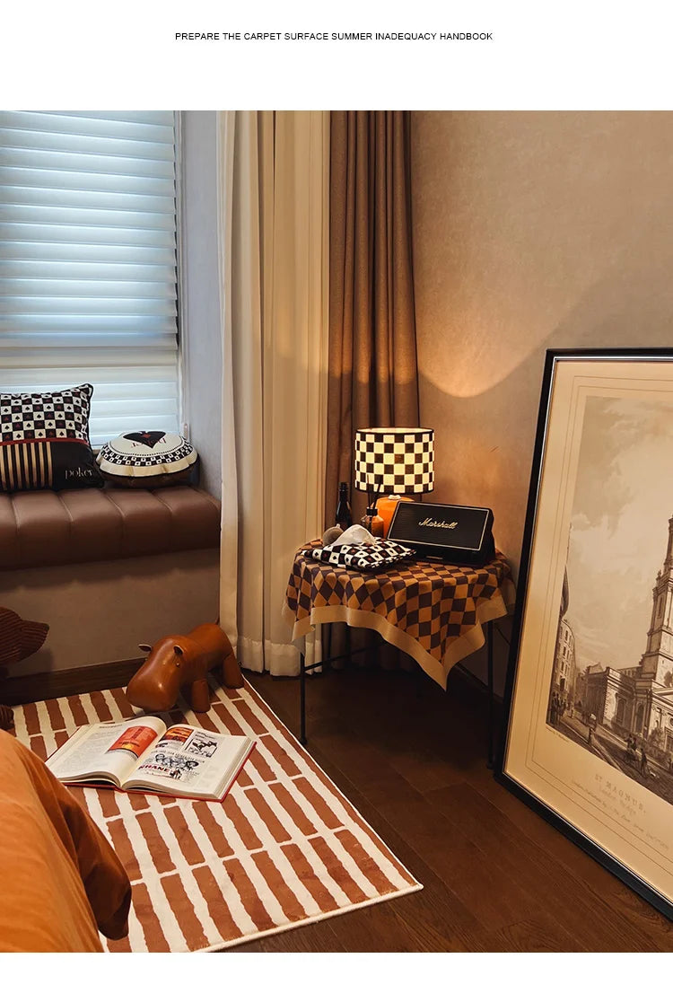 Living room with checkered lamp, table, and decor items.