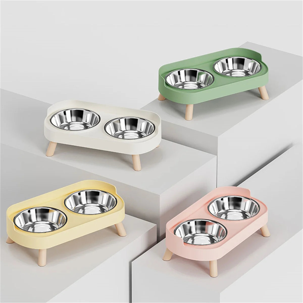 Four pet bowls with stands in different colors on a light gray background