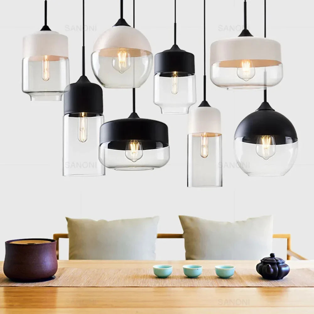 Various pendant lights hanging above a wooden table with tea sets.