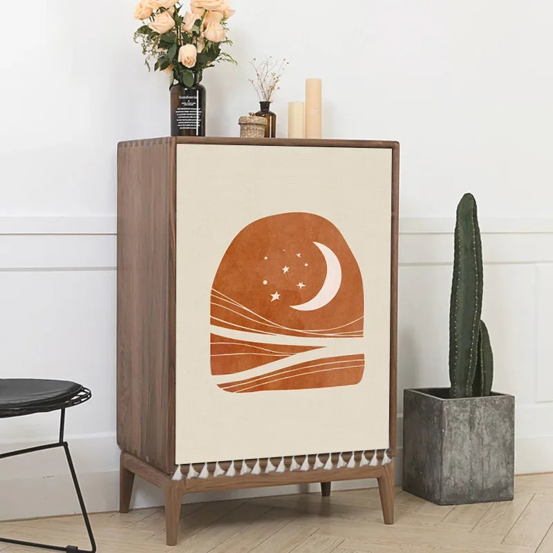 Wooden cabinet with decorative panel featuring a brown abstract design, placed against a white wall with a cactus and flowers.