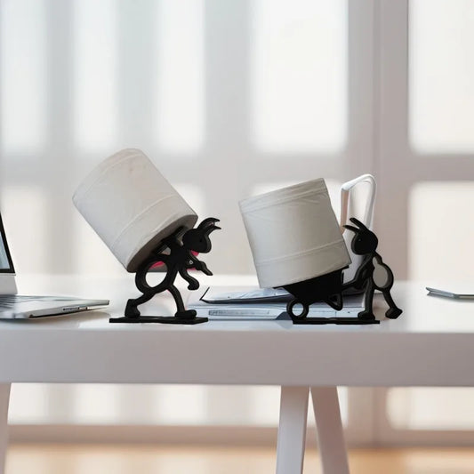 Two black rabbit-toilet roll holders on a desk.