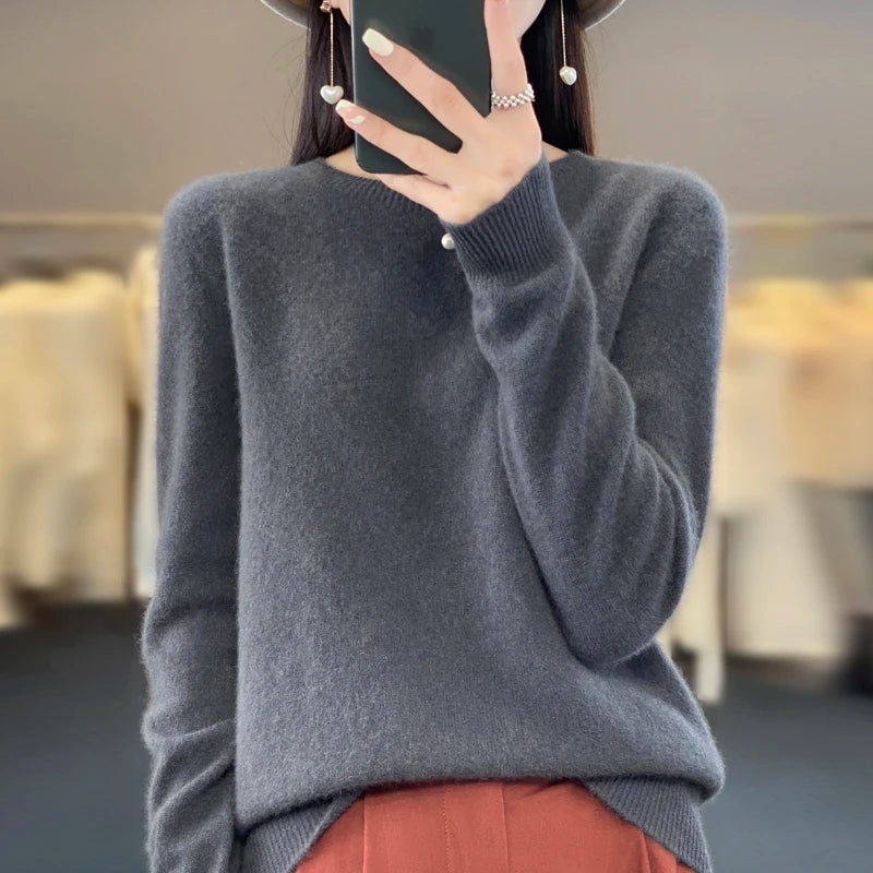 Person wearing a grey sweater with a blurred indoor background
