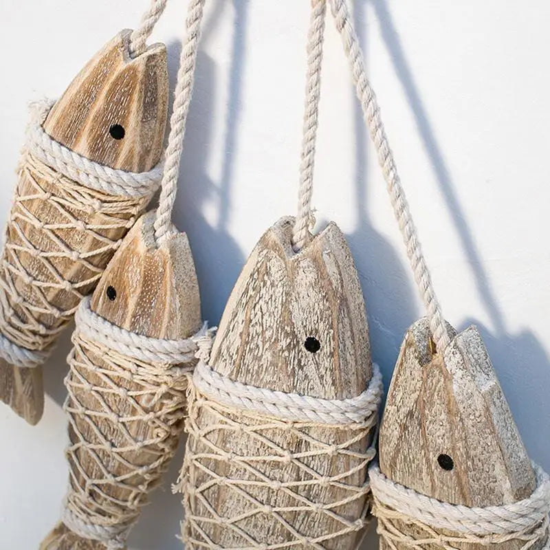 Wooden fish-shaped ornaments with rope against a white background
