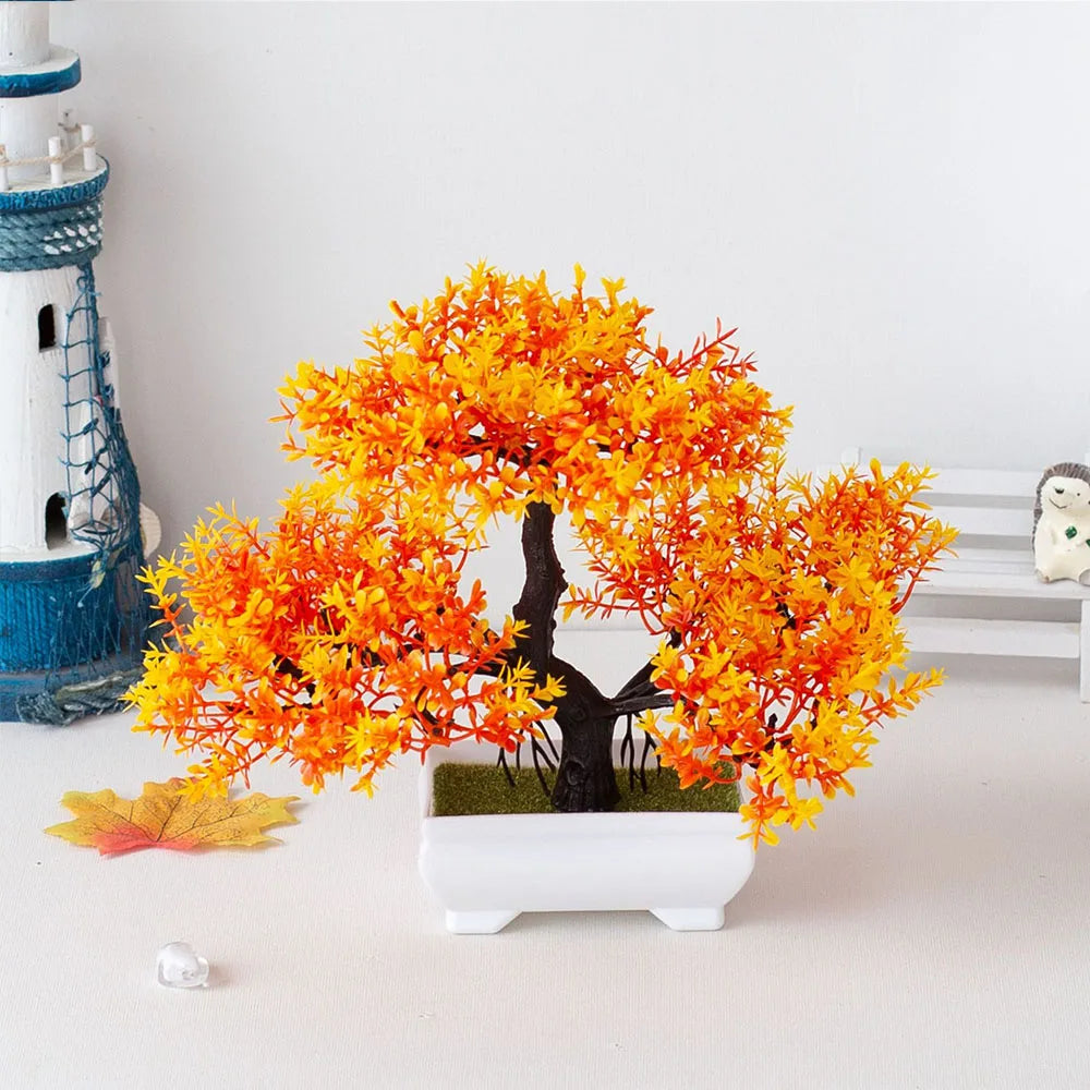 Artificial orange tree in a white pot on a light surface with a white wall background
