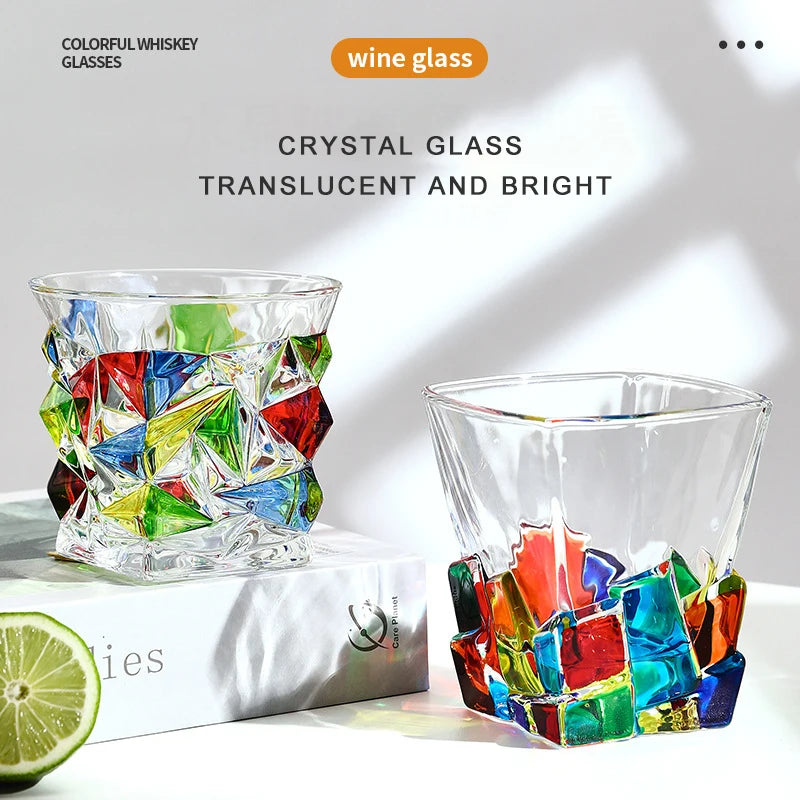 Two colorful crystal wine glasses on a white surface with a lime wedge.