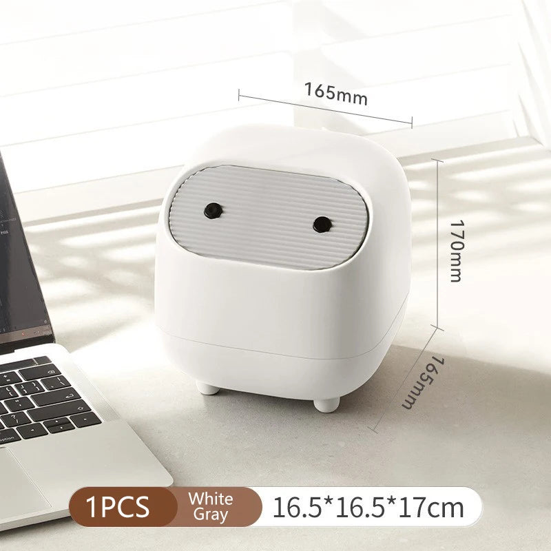 White and gray electronic device with dimensions displayed next to a laptop on a light surface.