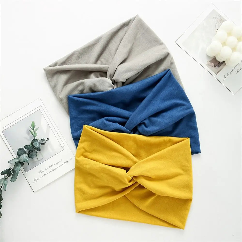 Three headbands in gray, blue, and yellow on a white surface with decorative elements.