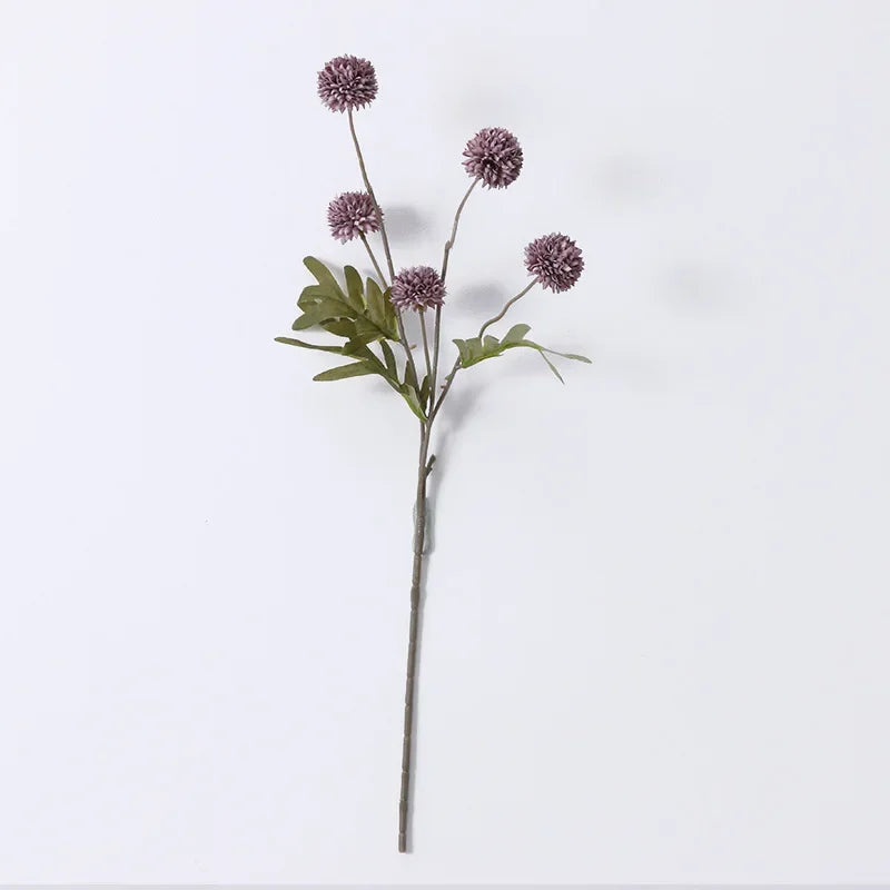 Artificial flower stem with purple flowers on a white background