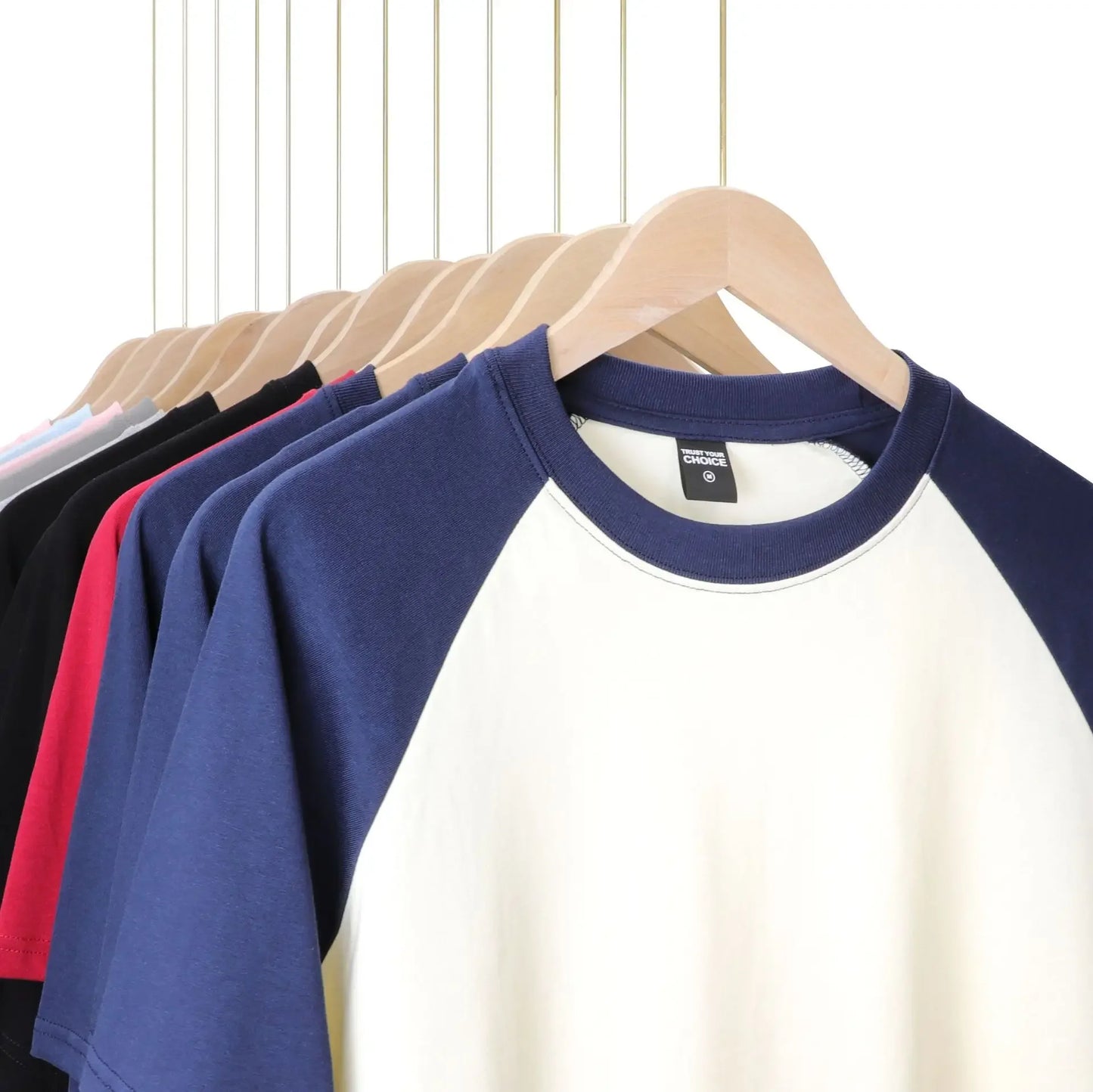 Row of colorful baseball shirts on hangers against a white background