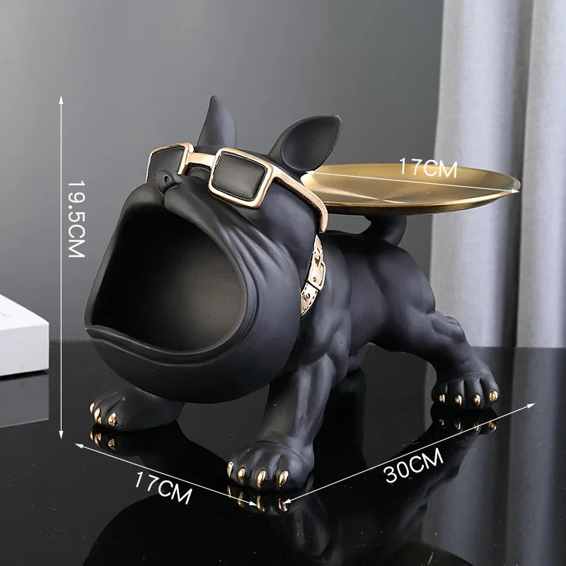 Black dog-shaped object with a gold tray on a dark surface