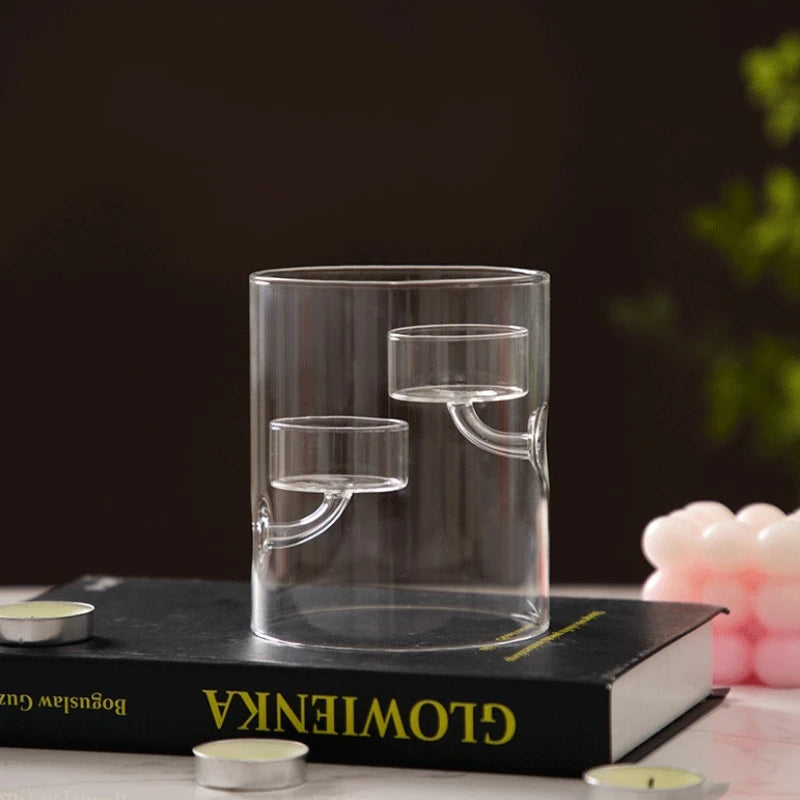 Clear glass candle holder on a book with candles around