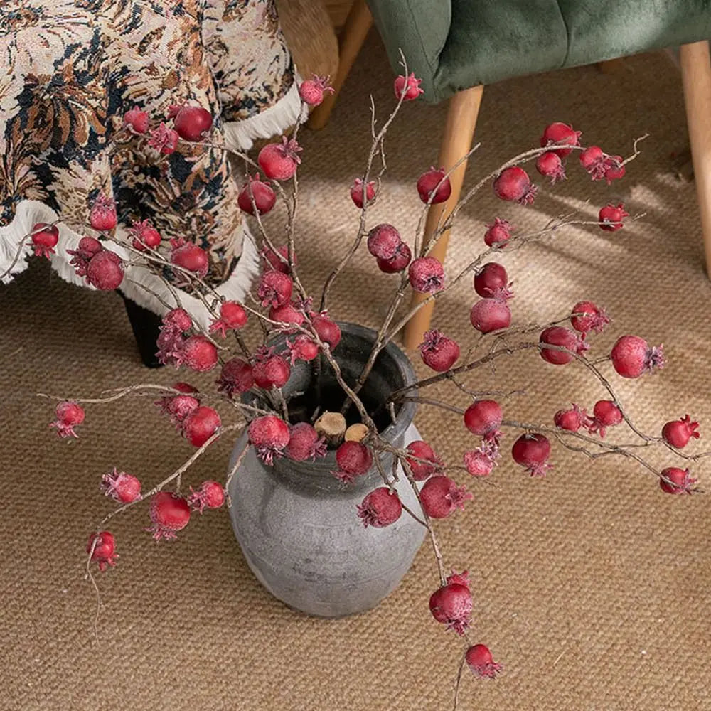 Decorative vase with red berries on a textured surface