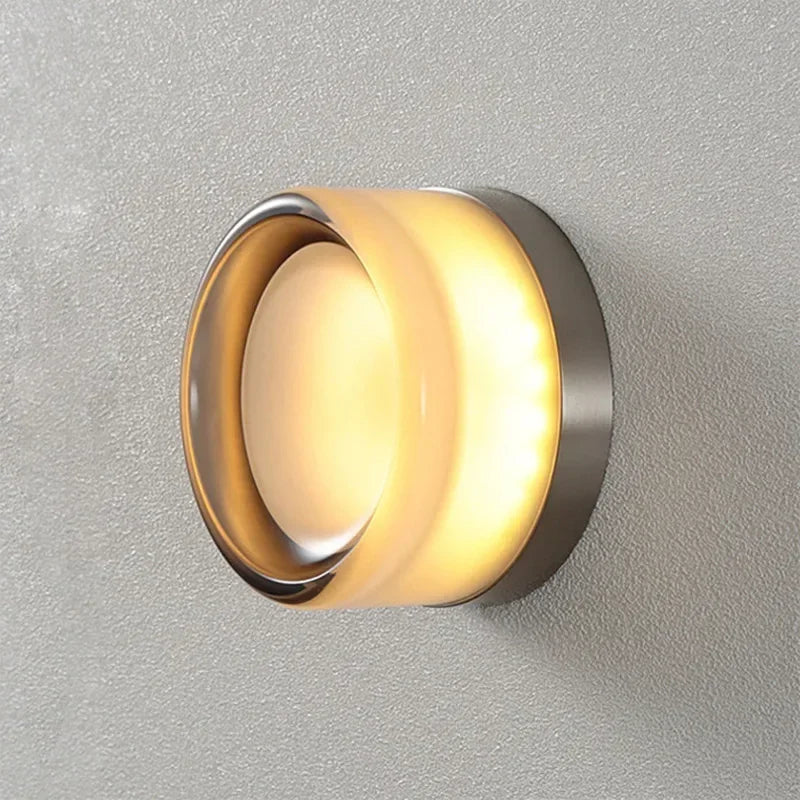 Wall-mounted light fixture with a metallic finish on a gray background