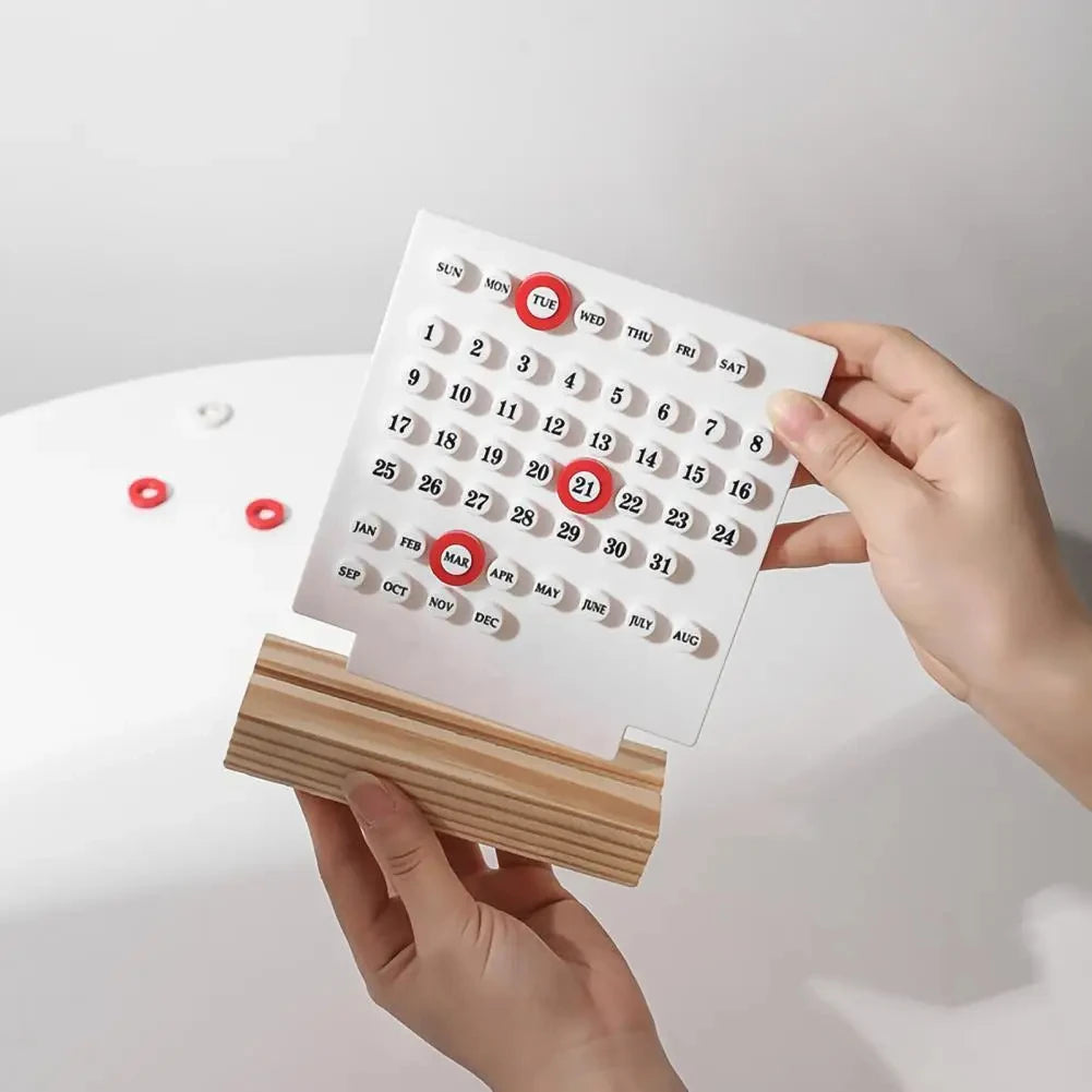 Calendar with wooden stand held by hands against a light background