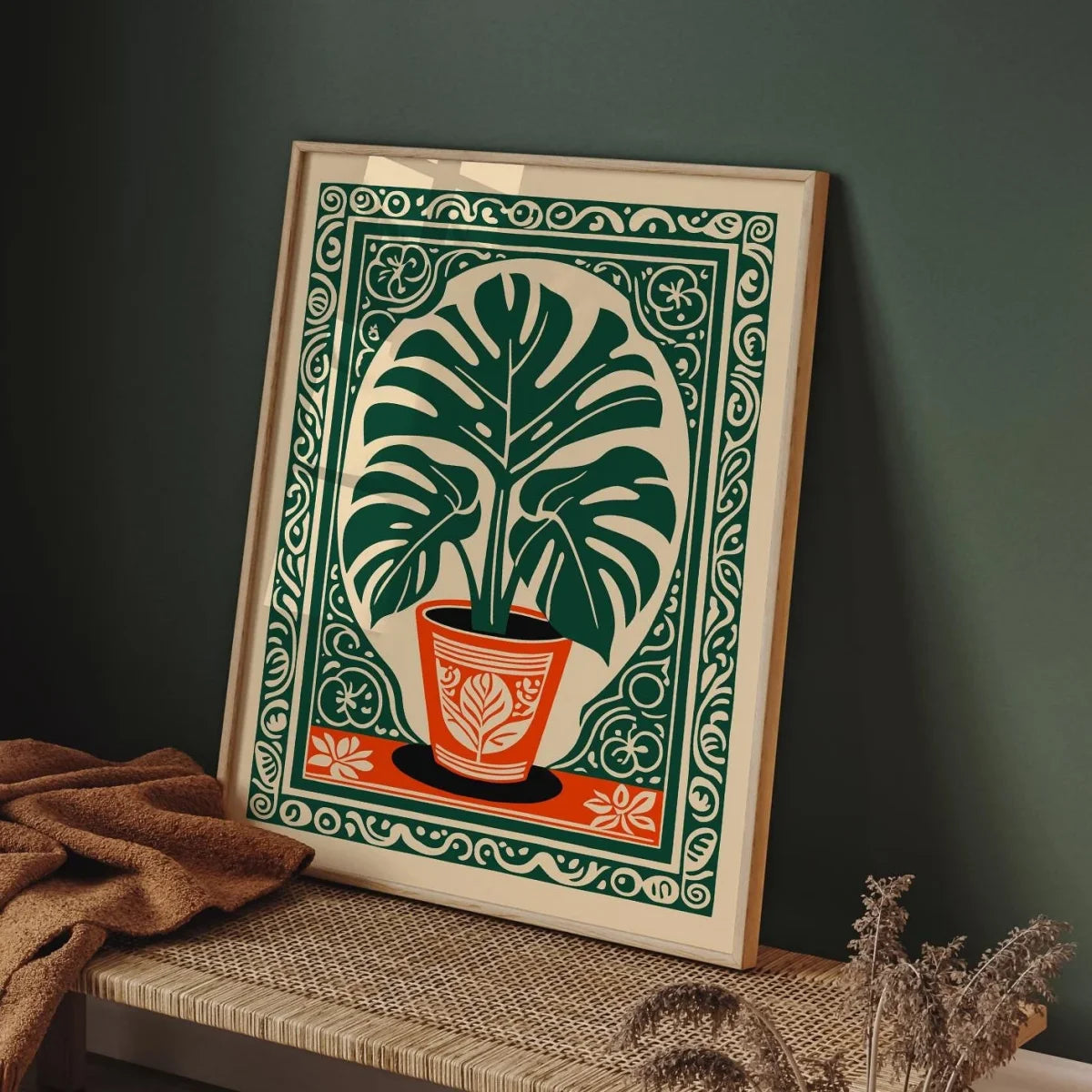Framed artwork of a potted plant with decorative border on a dark wall.