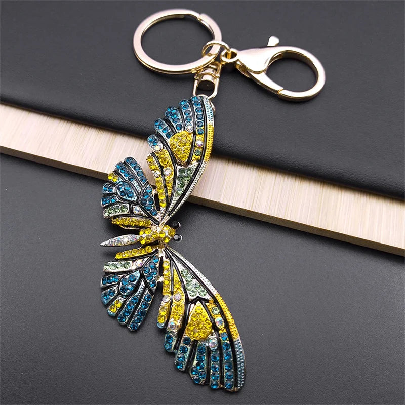 Decorative butterfly keychain with gemstones on a dark surface