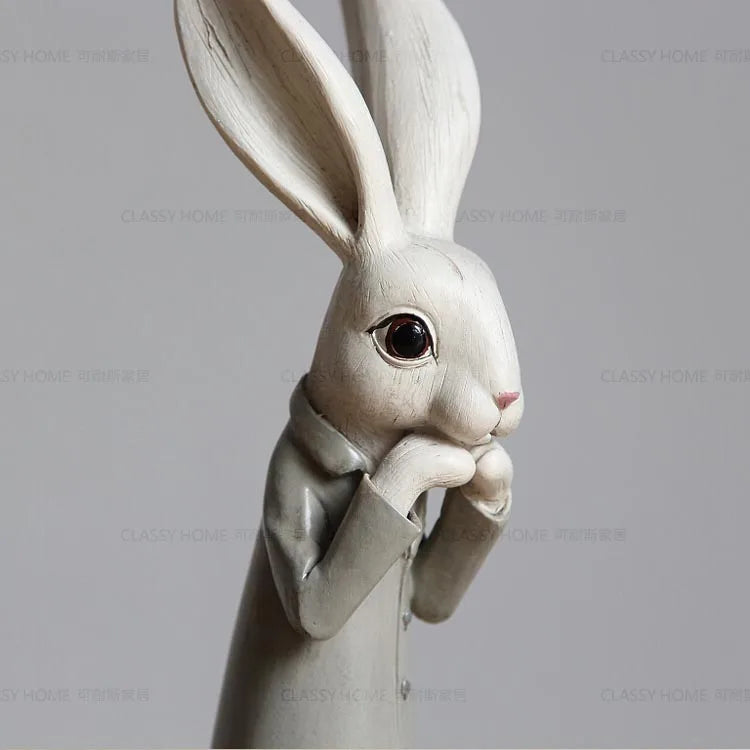 White rabbit figurine wearing a suit on a gray background
