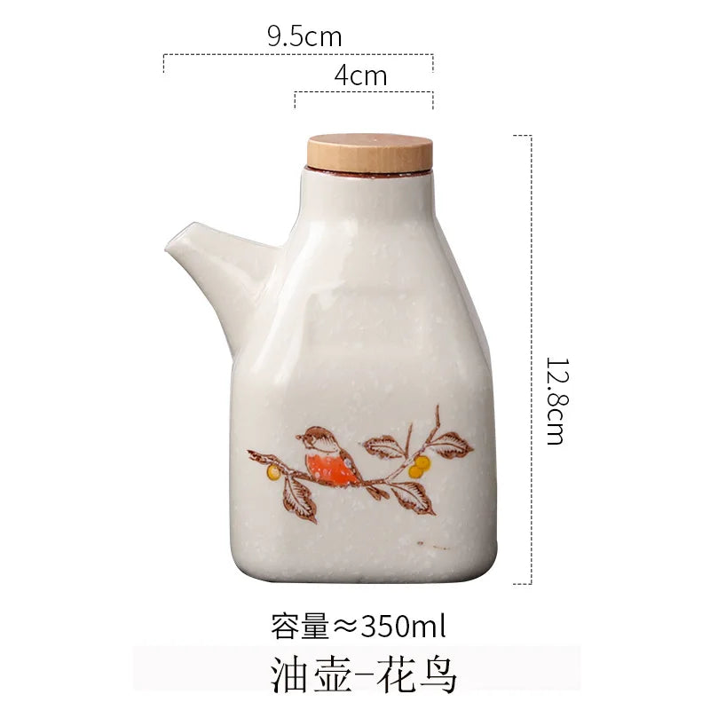 Ceramic oil bottle with wooden lid and bird design, shown with measurements on a white background.