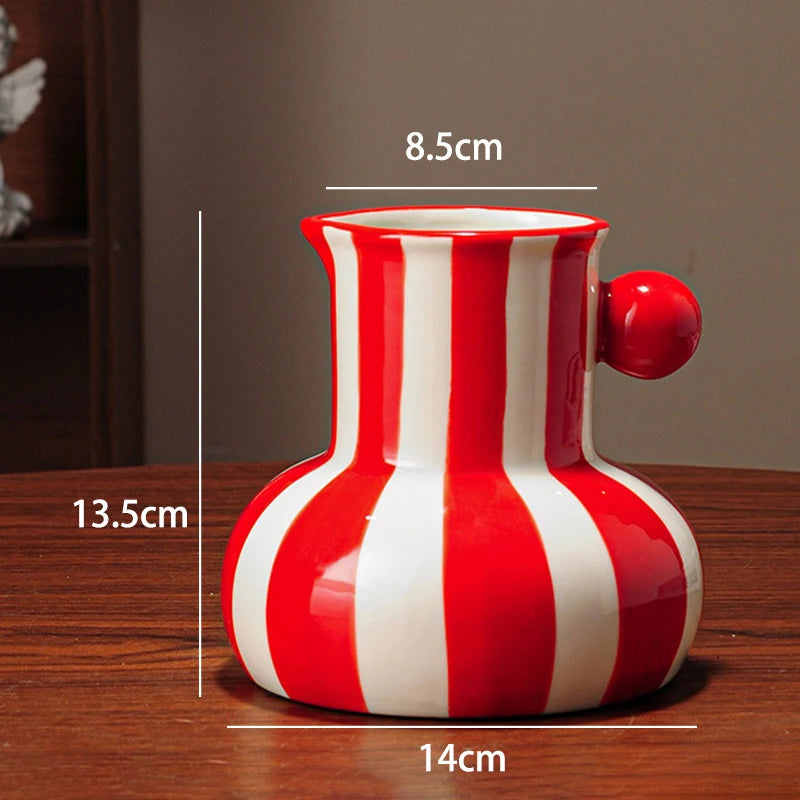 Red and white striped vase with measurements on a wooden surface
