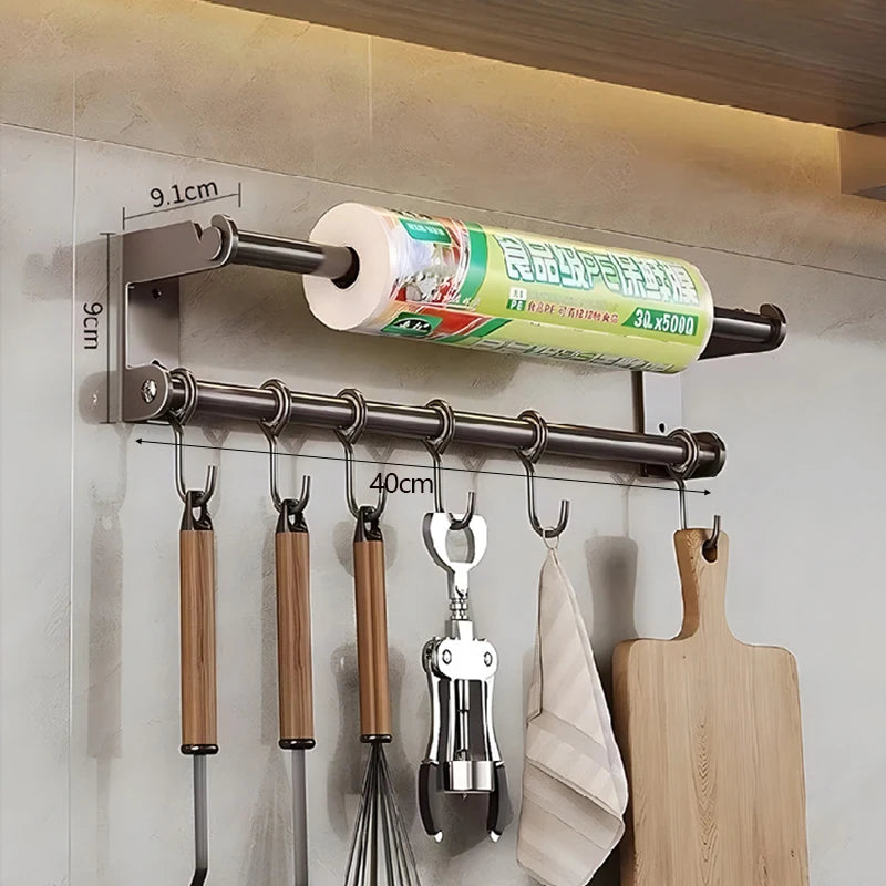 Wall-mounted kitchen organizer with hooks and a roll of paper towels.