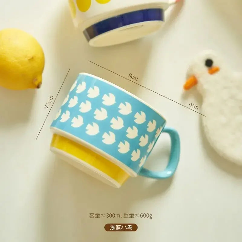 Blue mug with white bird pattern on a light surface, with measurements and text overlay.