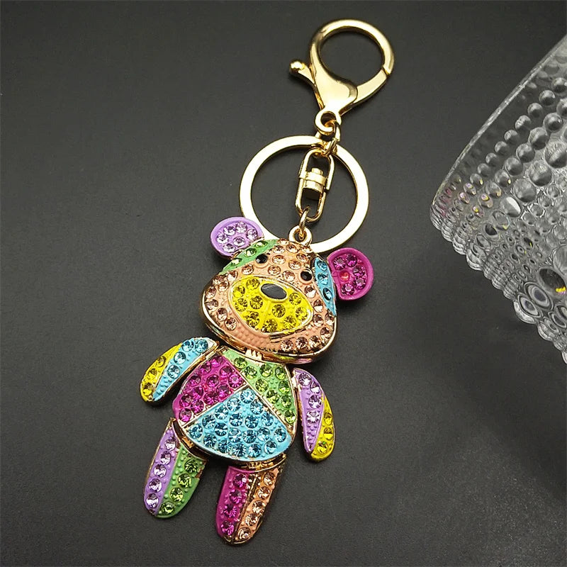 Colorful teddy bear keychain with rhinestones on a dark background