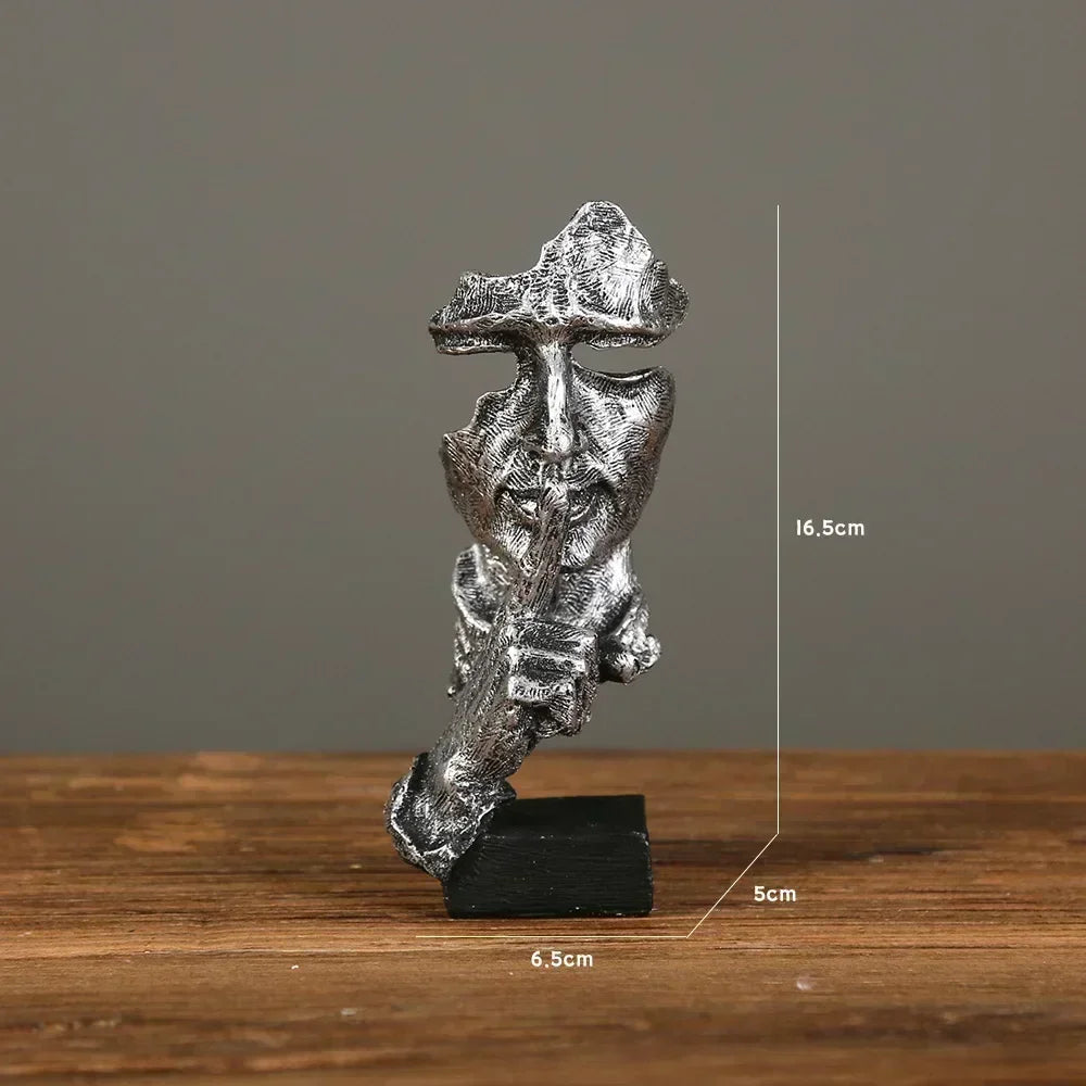 Silver statue on a wooden surface with measurements indicated