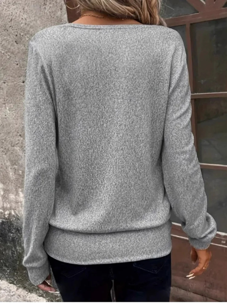 Person wearing a gray sweater with a neutral background