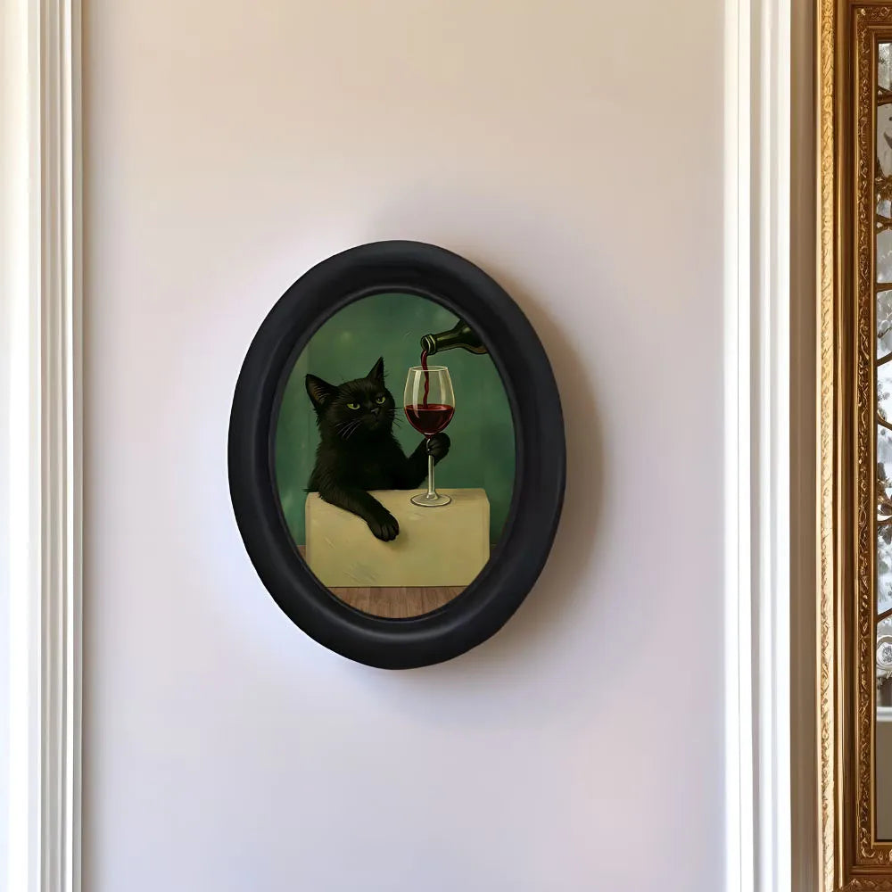 Framed artwork of a black cat with a glass of red wine on a white wall.