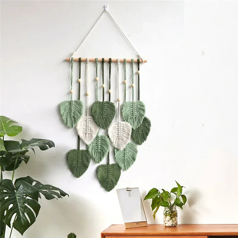 Decorative wall hanging with leaf patterns on a white wall.