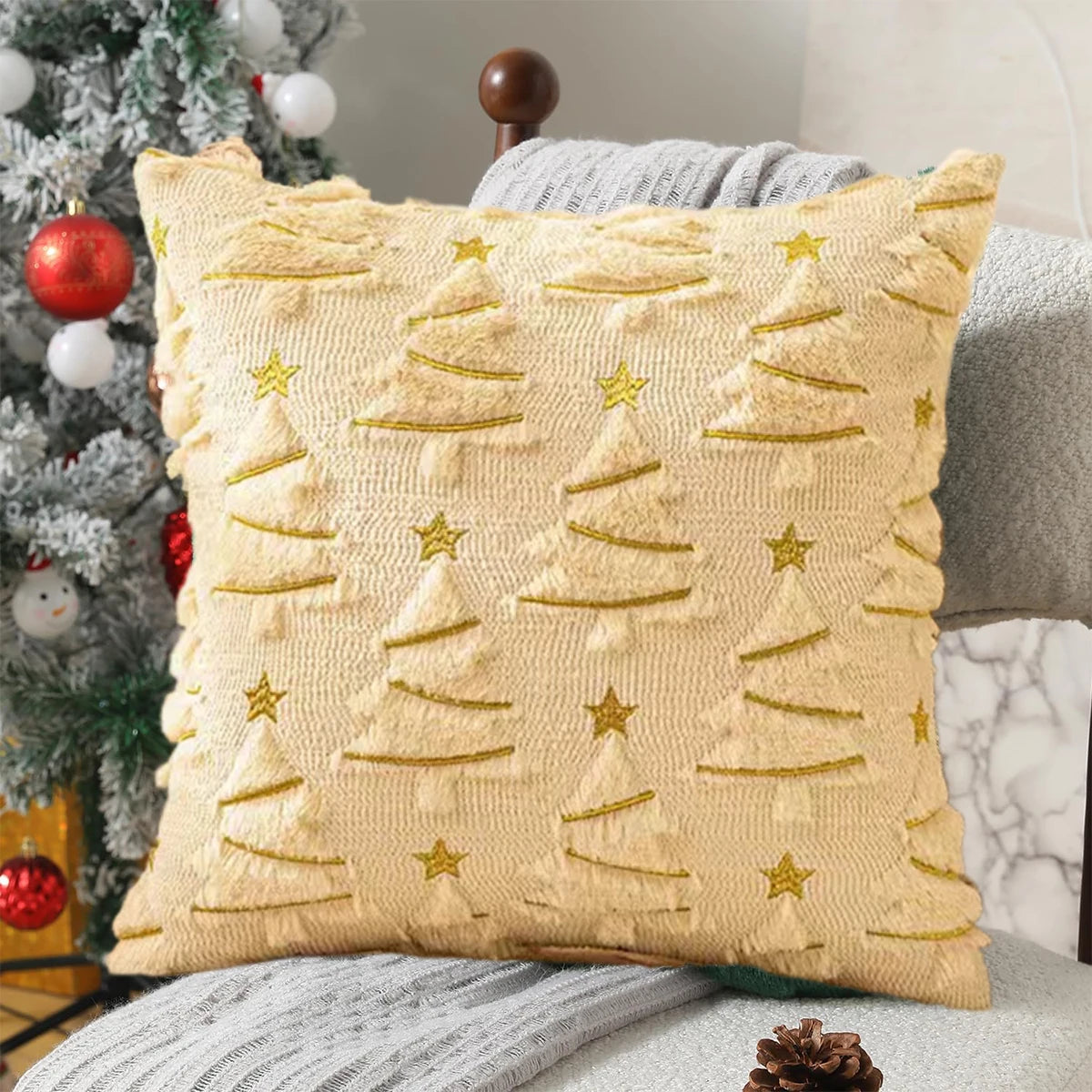Decorative pillow with Christmas tree pattern on a couch next to a Christmas tree.