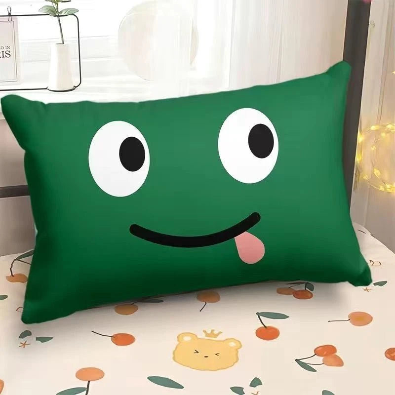 Green pillow with a smiley face on a bed with a floral pattern