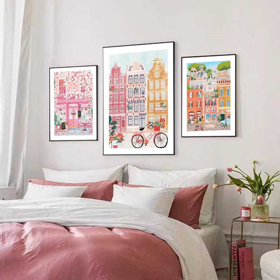 Bedroom with pink bedding and three framed artworks on the wall.