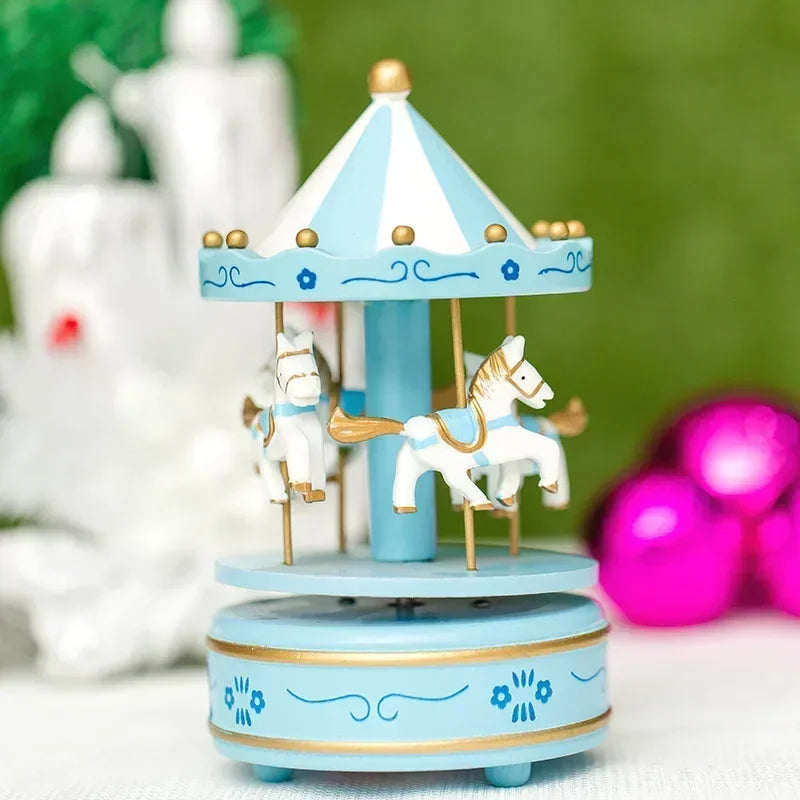 Small blue carousel toy with horses on a white surface with blurred colorful background