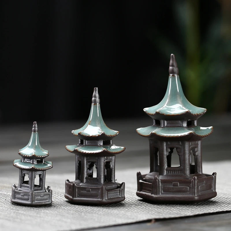 Three miniature pagoda models on a dark background