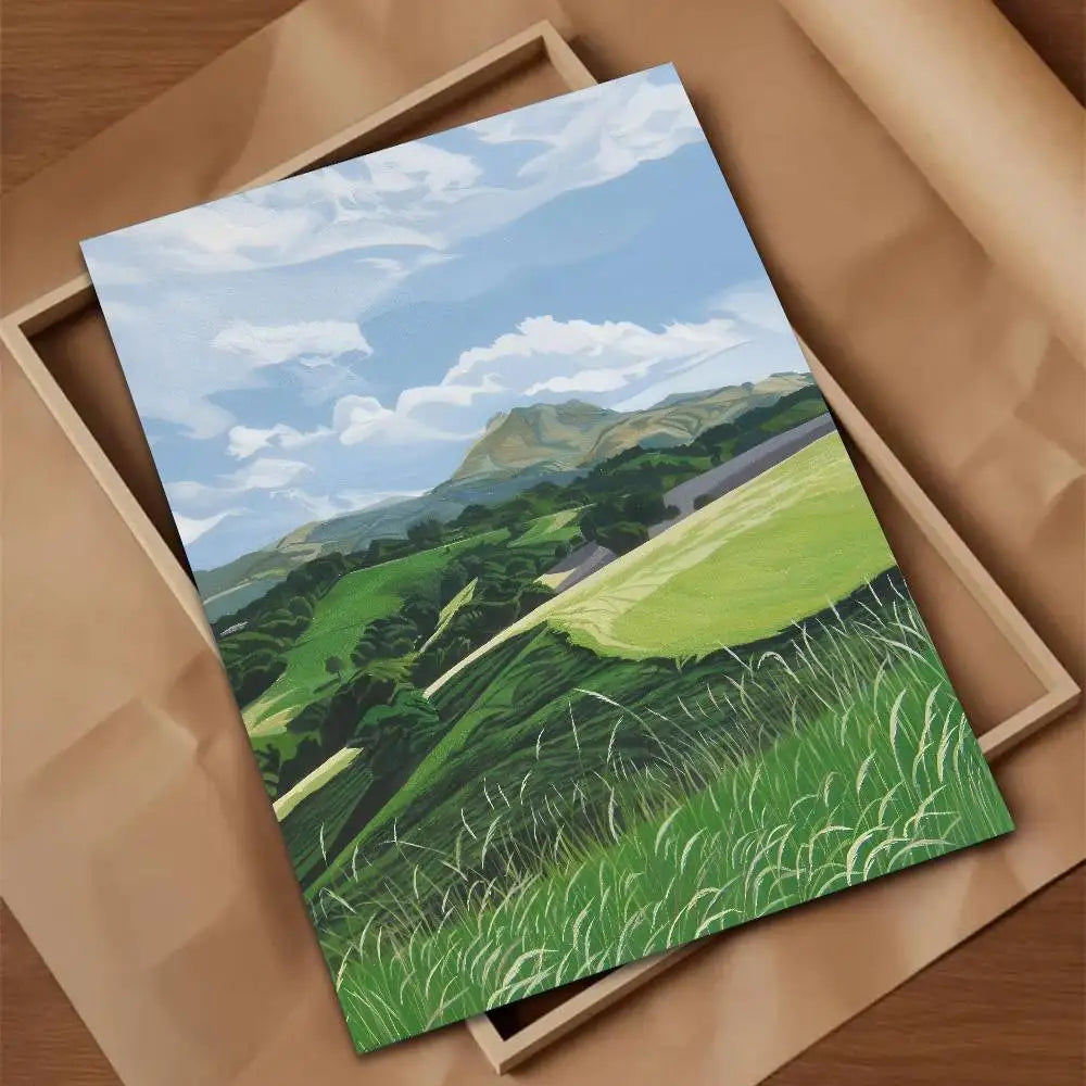 Painting of a landscape with green fields and mountains on a wooden surface